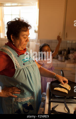 Hispanic woman cuisine pour petite-fille dans la cuisine Banque D'Images