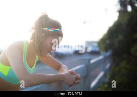 Close up of woman leaning over fence en stationnement Banque D'Images