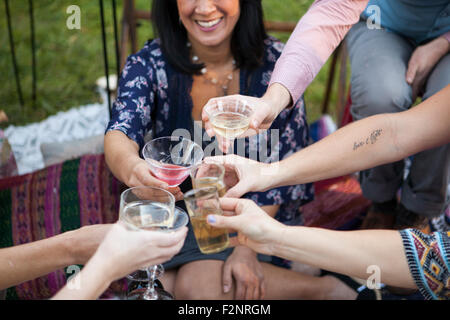 Friends toasting with champagne at picnic in park Banque D'Images