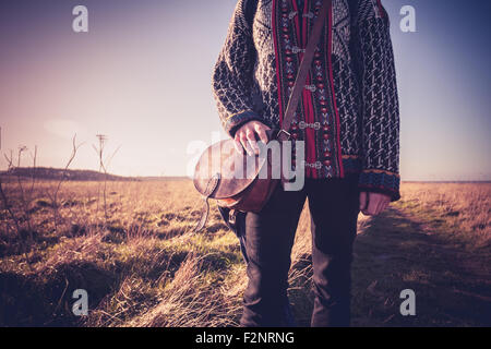 Young woman standing in field avec sac d'épaule Banque D'Images