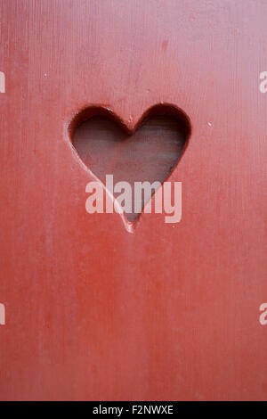 Peints en rouge avec du bois coupé d'un coeur Banque D'Images
