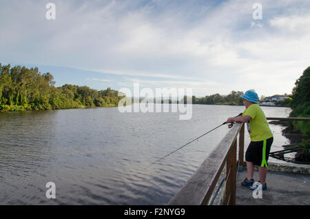 Un jeune garçon pêchant au bord d'une rivière en Nouvelle-Galles du Sud, en Australie Banque D'Images