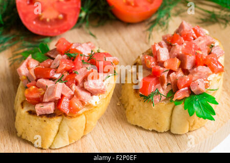 Crostini savoureux hors-d (crostino) avec de la tomate et de la saucisse Banque D'Images