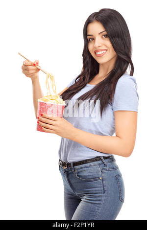Shot verticale d'une belle femme eating Chinese food avec des bâtons et regardant la caméra isolé sur fond blanc Banque D'Images