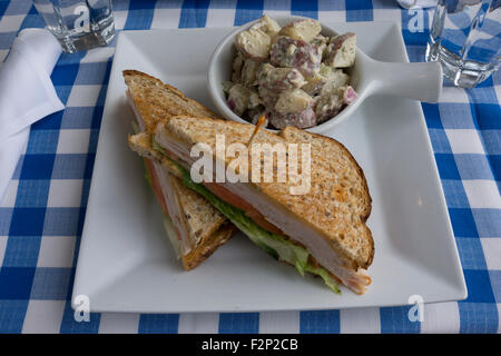 Un sandwich au poulet et la salade de pommes de terre comme servi dans un restaurant à Battery Park City, Manhattan, New York. Banque D'Images