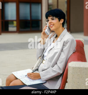 Jeune femme d'affaires parlant sur son téléphone cellulaire dans la rue de ville France Europe Banque D'Images