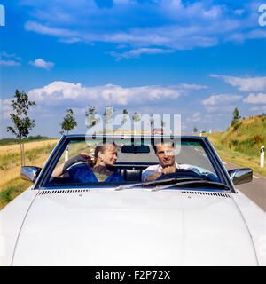 Couple au volant d'une voiture décapotable Mercedes on country road, Alsace, France Banque D'Images