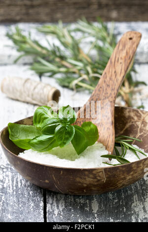 Le sel de mer à l'aide de fines herbes : basilic, romarin sur un fond de bois Banque D'Images