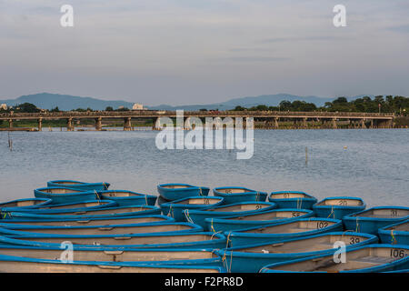 Le pont Togetsukyo à travers la rivière Katsura Arashiyama en aviron avec bateaux amarrés dans l'avant-plan Banque D'Images