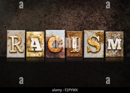 Le mot "racisme" écrit en métal rouillé type typographique sur une texture grunge fond sombre. Banque D'Images