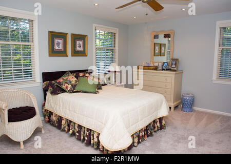 Vue de la chambre d'une maison, y compris un lit et une commode, d'un ventilateur de plafond. Banque D'Images
