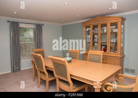 L'intérieur de salle à manger avec une grande table en bois, chaises, et la Chine du cabinet. Banque D'Images