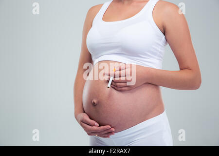 Portrait d'une femme enceinte cigarette isolé sur fond blanc Banque D'Images