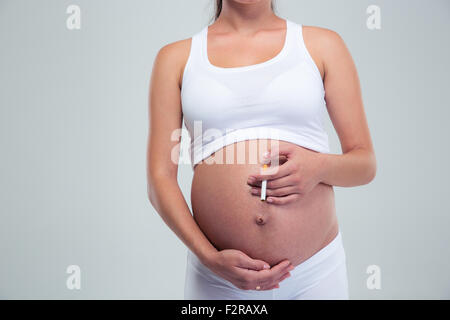 Femme enceinte cigarette isolé sur fond blanc Banque D'Images