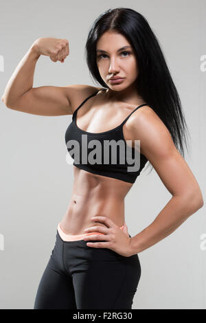 Portrait de jeune femme montre fitness biceps. Banque D'Images