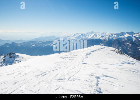 Retour sur des pistes de ski de fond et le sommet de la crête avec vue majestueuse de l'arc alpin dans un paysage d'hiver. Ciel bleu clair. Banque D'Images