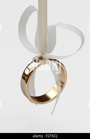 Bague de mariage en or avec noeud sur fond blanc Banque D'Images