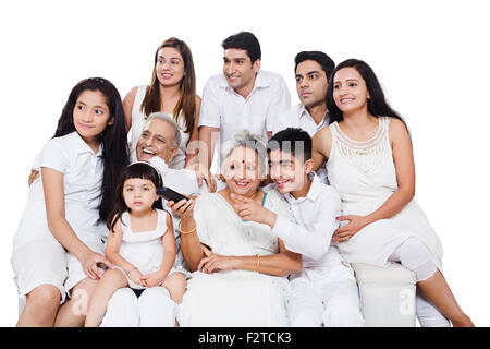 Groupe indien famille mixte assis à regarder la télévision canapé Banque D'Images