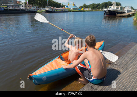 OMMEN, Pays-Bas - 9 août 2015 : deux garçons jouant avec leur canot dans la rivière Regge. La zone de Regge est une h Banque D'Images