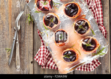 Figues au four avec du fromage et du romarin, enrobé de bacon. Banque D'Images