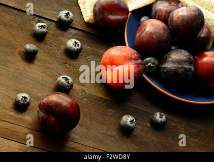 Prunes fraîches de lumière naturelle avec moody vintage style. Vie saine food concept. La vie encore. Banque D'Images