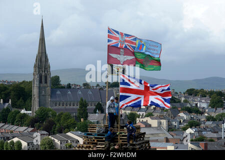 Les jeunes nationalistes debout sur un grand feu fait à partir de palettes en bois, dans le Bogside, Londonderry, en Irlande du Nord. Banque D'Images