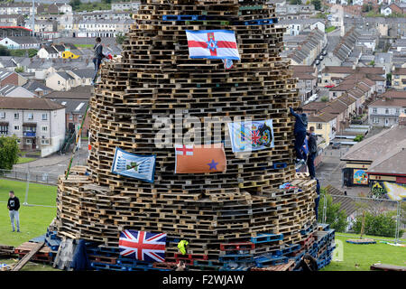 Les jeunes nationalistes debout sur un grand feu fait à partir de palettes en bois, dans le Bogside, Londonderry, en Irlande du Nord. Banque D'Images