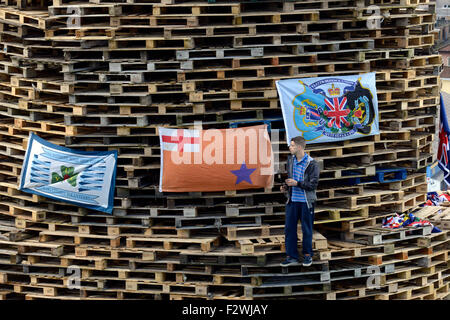 La jeunesse nationaliste debout sur un grand feu fait à partir de palettes en bois, dans le Bogside, Londonderry, en Irlande du Nord. Banque D'Images