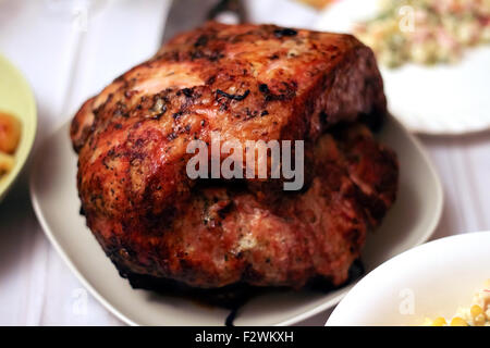 Le morceau de viande de porc cuit au four avec des herbes et épices sur une table de vacances. ** Note : flou à 100 %, les meilleures à des tailles plus petites Banque D'Images