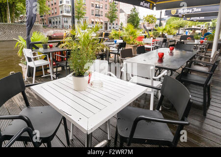 Table de salle à manger sur une véranda à l'extérieur d'un bar d'Amsterdam à côté d'un canal. Banque D'Images