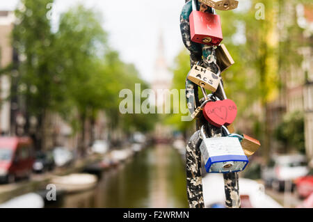 Cadenas attachés à la chaîne d'un pont sur un canal à Amsterdam, à gauche par les amateurs de montrer leur amour. Banque D'Images