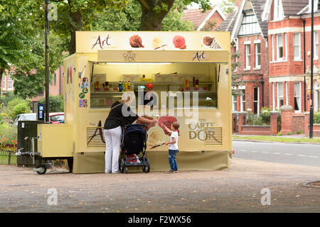 Maman donnant cornet de crème glacée à la crème glacée au garçon sur le remblai du vendeur à Bedford, Bedfordshire, Angleterre Banque D'Images