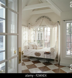 Coronet avec rideaux voile blanc sur windows derrière un lit en fer forgé en 90 chambres Banque D'Images