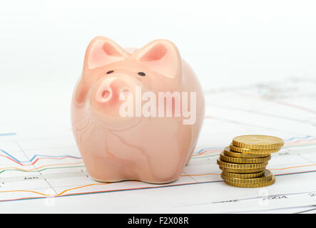 Piggy bank with coins sur les documents Banque D'Images