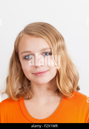 Smiling blonde Caucasian teenage girl, portrait studio gros plan sur fond gris clair Banque D'Images