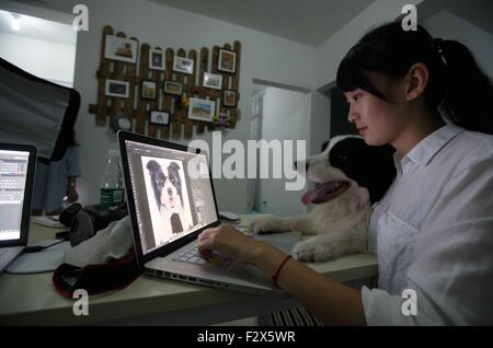 (150925) -- BEIJING, 25 septembre 2015 (Xinhua) -- Zong Wenqi, le fondateur d'Xiaoha Animal Studio de photographie, d'édition de photos comme son animal de compagnie à Harry garde son animal de compagnie Xiaoha Studio de photographie à Nantong, Province du Jiangsu en Chine de l'Est, le 17 septembre, 2015. Zong Wenqi et Ni Jiangling, nés après 1990, étaient des camarades de classe de Nantong Normal College. Les deux d'entre eux comme des animaux et la photographie. Zong Wenqi même voulu être un animal professionnel photographe comme elle a obtenu une confiance dans l'enregistrement de son chien Harry par la photographie. Quand les deux jeunes filles avaient à faire un choix à la fin de leurs études, ils ont décidé d'ouvrir un animal de ph Banque D'Images