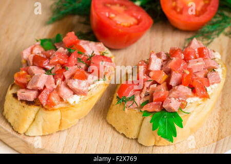 Crostini savoureux hors-d (crostino) avec de la tomate et de la saucisse Banque D'Images