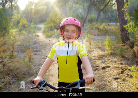 Kid girl biker en vtt MTB à forêt méditerranéenne Banque D'Images