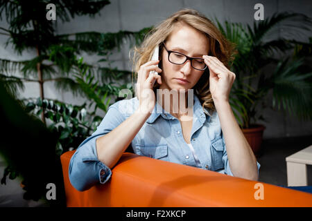 Belle jeune businesswoman with contrariée sur le visage experssion, using laptop in office. Banque D'Images