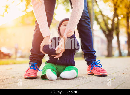 Heureux jeune mère avec son fils lors d'une promenade en ville d'automne Banque D'Images