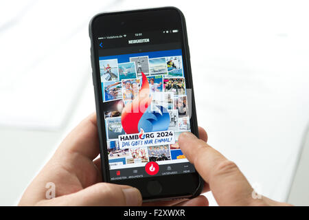 Hambourg, Allemagne. 25 Septembre, 2015. ILLUSTRATION - un homme démontre la nouvelle 'Hamburg 2024' app sur son smartphone, à Hambourg, Allemagne, 25 septembre 2015. Les pro-olympiades campagne "Feuer und Flamme' (lit. Feu et flamme) mis au point l'app qui dispose d'informations sur la tenue des Jeux Olympiques d'Hambourg. PHOTO : CHRISTIAN CHARISIUS/DPA/Alamy Live News Banque D'Images