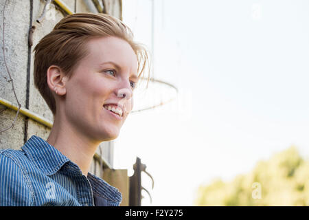 Jeune femme sur une ferme, en faisant une pause à l'ombre d'un silo. Banque D'Images