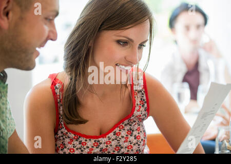 Un couple assis dans un restaurant à un menu. Banque D'Images