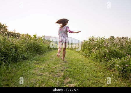 Une femme en marche le long d'un chemin dans un pré. Banque D'Images