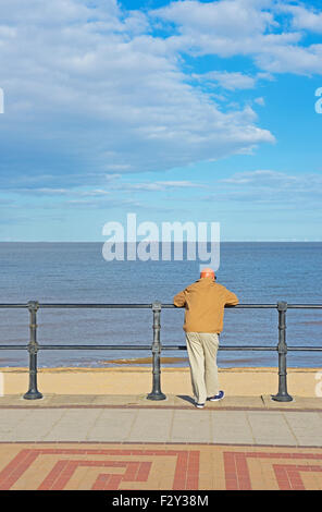 Homme d'âge moyen sur la promenade, regardant vers la mer, Grimsby, Lincolnshire, Angleterre, Royaume-Uni Banque D'Images