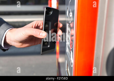 L'homme doit payer son ticket de transport avec son téléphone mobile sur la plate-forme. NFC Banque D'Images
