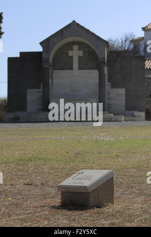 Seul face à tombstone la Grande Croix Cove memorial en arrière-plan. Cimetière militaire de Portianos CWGC. L'île de Limnos, Grèce Banque D'Images