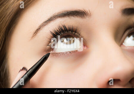 Closeup portrait brune s traitement maquillage styliste professionnel par l'application de l'eyeliner Banque D'Images