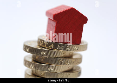 Maison modèle SUR UNE PILE DE PIÈCES LIVRE RE ACCUEIL ACHATS CENTRALE D'ACHAT DE LA PROPRIÉTÉ DU LOGEMENT PRÊTS HYPOTHÉCAIRES DU MARCHÉ DE L'ÉCHELLE DES REVENUS LES TAUX D'INTÉRÊT Royaume-uni Banque D'Images