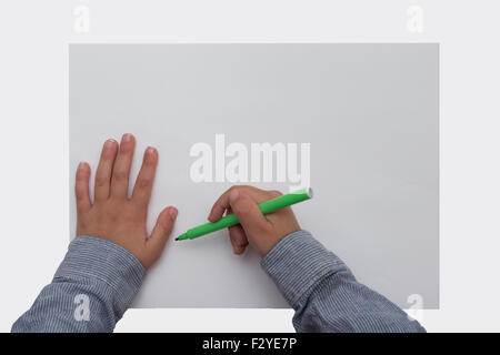 Enfant tenant plume sur feuille de papier vierge Banque D'Images